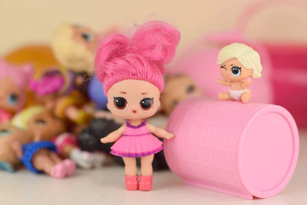 Много разноцветных пластиковых LOL на столе. Игрушки серии LOL Surprise производства MGA Entertainment inc . — стоковое фото