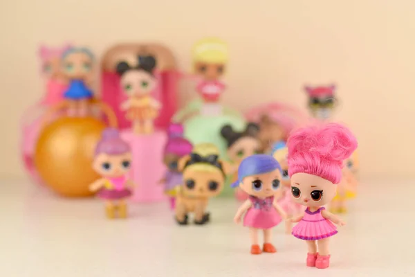 Πολλές πολύχρωμες πλαστικές κούκλες Lol στο τραπέζι. Παιχνίδια της σειράς Lol Έκπληξη από την Mga Entertainment inc. — Φωτογραφία Αρχείου