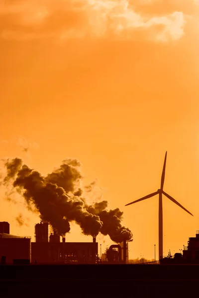 日没時に煙突と風車を持つオランダの工業プラント — ストック写真