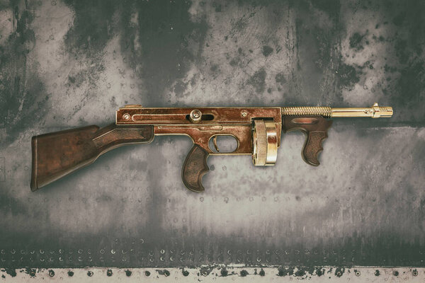 Винтажный пулемет золотого цвета перед старой выветриваемой раковиной
