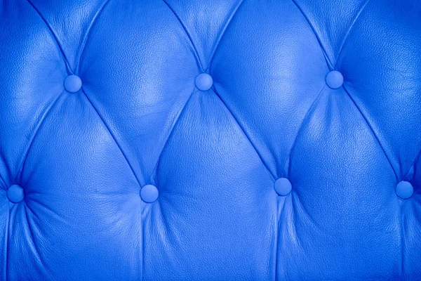 Blauer Hintergrund Muster Eines Chesterfield Geknöpft Ledersofa lizenzfreie Stockfotos