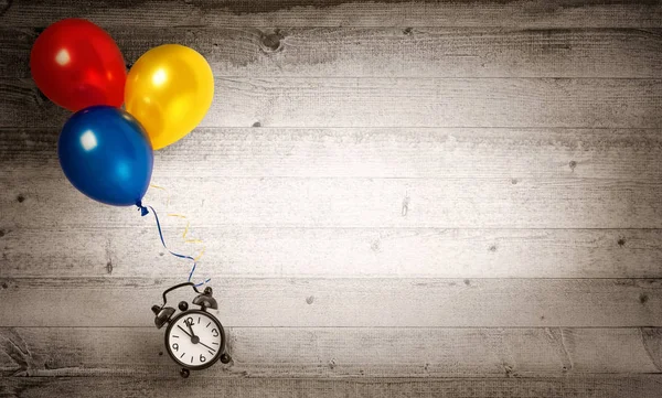 Reloj volando con varios globos sobre un fondo de madera —  Fotos de Stock