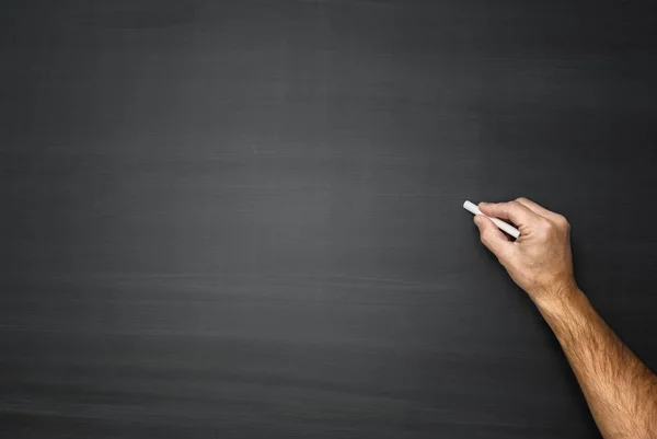 Hand writing on a black blank chalkboard — Stock Photo, Image