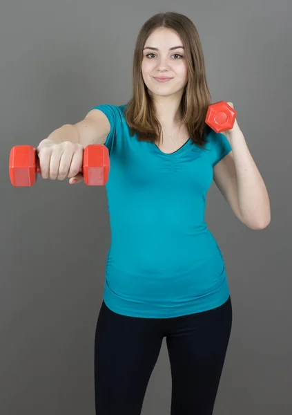 Mädchen mit Glocken auf grauem Hintergrund Sport-Konzept Turnhalle — Stockfoto