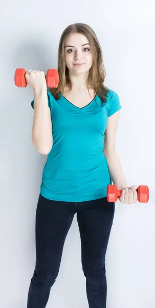 Flicka med dumpbells på vit bakgrund sport koncept gym — Stockfoto