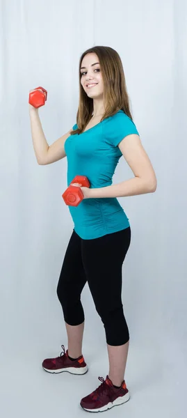 Flicka med dumpbells på vit bakgrund sport koncept gym — Stockfoto