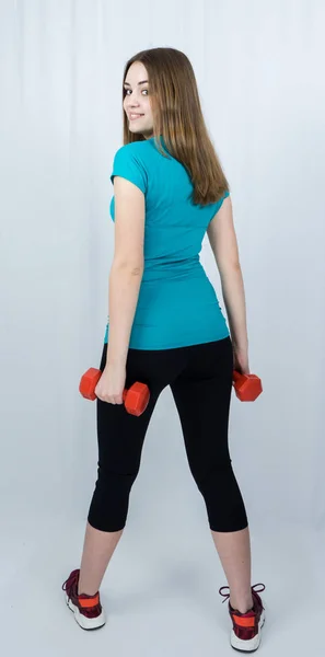 Dívka s dumpbells na bílém pozadí sport koncept posilovny — Stock fotografie