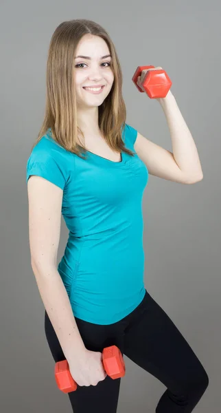 Mädchen mit Glocken auf grauem Hintergrund Sport-Konzept Turnhalle — Stockfoto