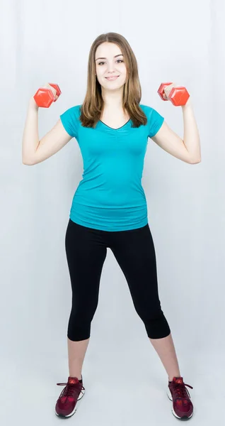 Flicka med dumpbells på vit bakgrund sport koncept gym — Stockfoto