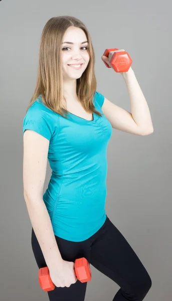 Mädchen mit Glocken auf grauem Hintergrund Sport-Konzept Turnhalle — Stockfoto