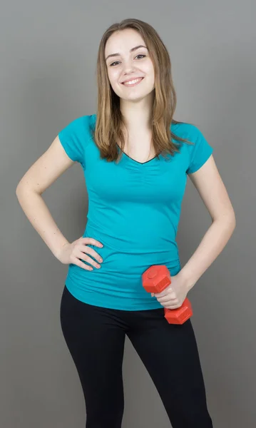 Girl with dumpbells on grey background sport concept gym — Stock Photo, Image