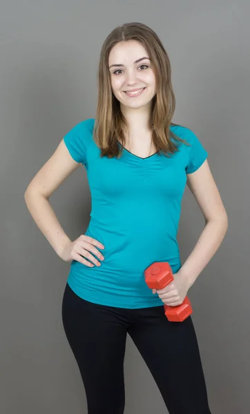 Mädchen mit Glocken auf grauem Hintergrund Sport-Konzept Turnhalle — Stockfoto