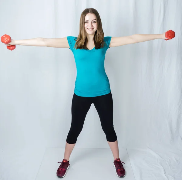 Girl with dumpbells on white background sport concept gym — Stock Photo, Image