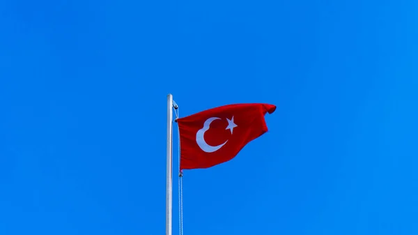 Turkisk flagga viftar i blå himmel — Stockfoto