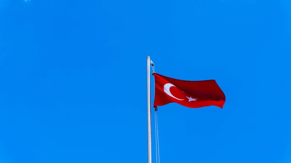 Flaga turecka machająca błękitnym niebem — Zdjęcie stockowe