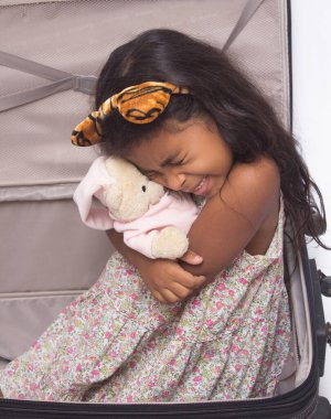 Güzel bir kız bir bavulun içinde oynuyor, beyaz tenli..