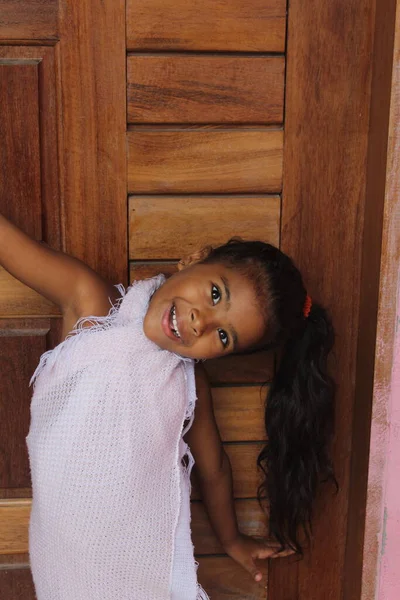 かわいい女の子の肖像画 彼女はあなたの古い木製のドアを持っている アフリカ系アメリカ人の混合人種の子供 — ストック写真