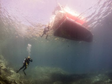 Dalgıçla ve teknenin dibiyle sualtı manzarası