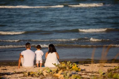 Sahilde oturan genç mutlu aile