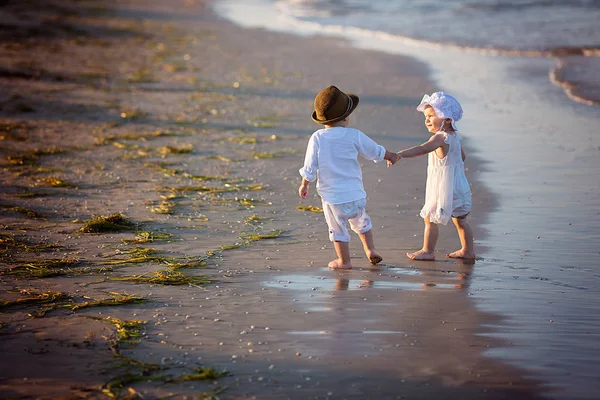Duas crianças lindas caminhando ao longo da costa — Fotografia de Stock