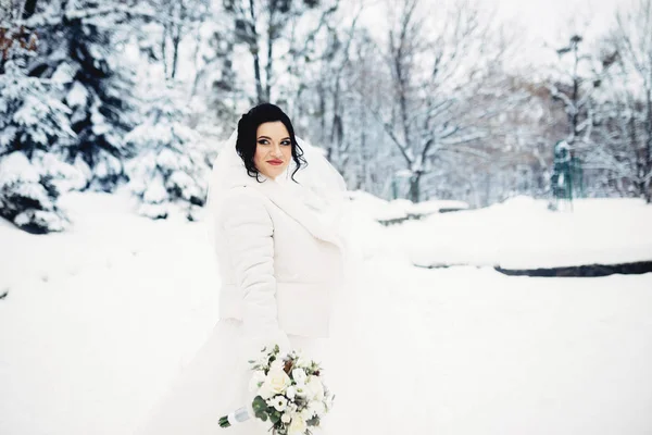 Portret panny młodej niesamowite. Bukiet, śnieg, zima. — Zdjęcie stockowe