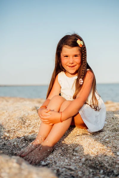 Deniz kıyısı yürüyüş güzel kız. Kumsalda oturuyor. Gülümseyerek. Uzun saç. — Stok fotoğraf