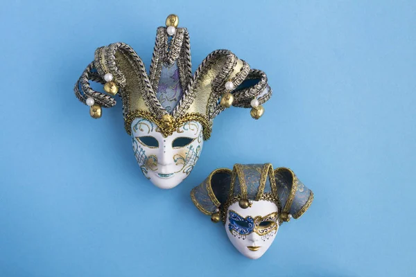 Two venetian carnival masks in the center of the blue background. Top view. Copy space.