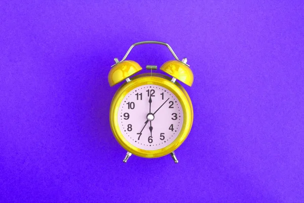 紫色の背景の中央に金の目覚まし時計 最上階だスペースのコピー — ストック写真