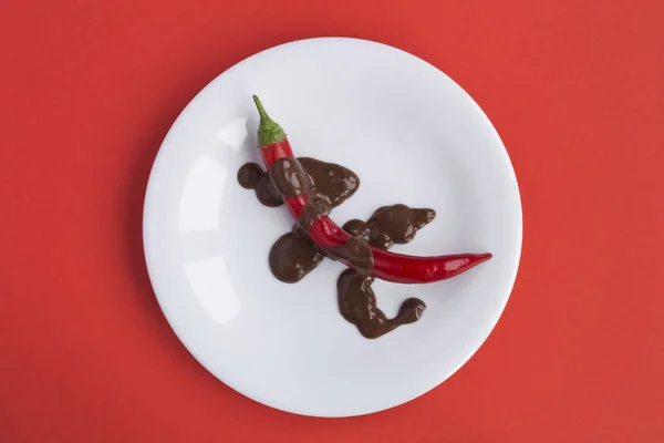 Chile Pimenta Vermelha Com Chocolate Placa Branca Centro Fundo Vermelho — Fotografia de Stock