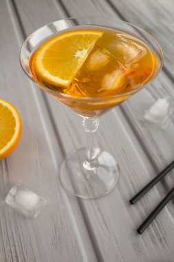 Gri ahşap arka planda martini bardağında Aperol spritz kokteyli. Konum dikey. Boşluğu kopyala.