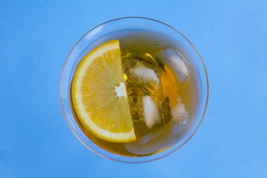 Aperol sprey kokteyli ya da mavi arkaplanın ortasında martini bardağında portakal kokteyli. Üst Manzara. Uzayı kopyala Yakın çekim..