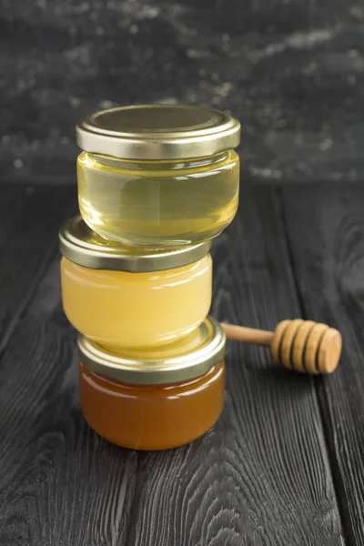 Different Varieties Honey Small Glass Jars Black Background Location Vertical — Stock Photo, Image