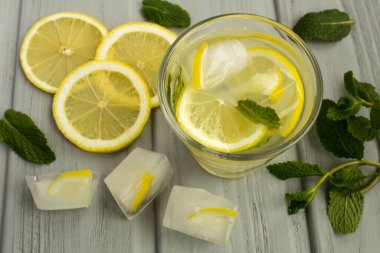 Limonlu ev yapımı limonata ve gri ahşap arka planda nane. Yukarıdan bak..