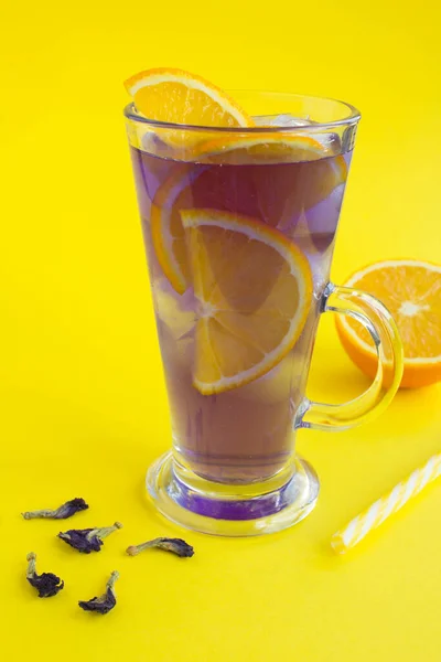 Ledově Modrý Květinový Čaj Pomerančem Sklenici Žlutém Pozadí Umístění Vertikální — Stock fotografie