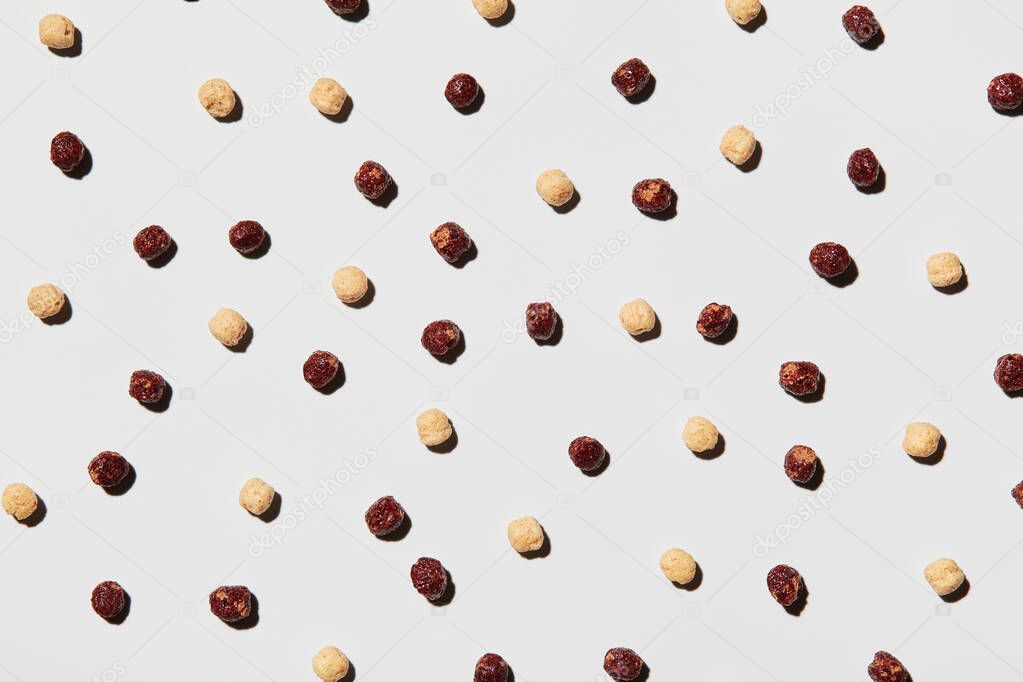 A lot of rice cereal arranged on a white background, pattern for designers. food background. Texture of chocolate cereal balls for background