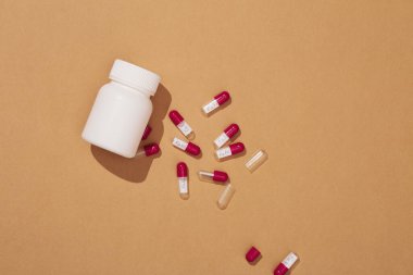 Beyaz tablet şişesi ve kahverengi arka planda sahte yazan bir sürü hap. Sahte ilaç konsepti. Sahte ilaç fikri..