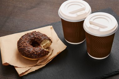 Kahverengi ahşap bir masada kahve ve çöreklerle dolu demir bir fincan gibi. Karanlık retro natürmort. Eski tarz.