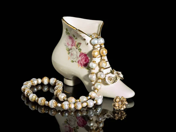 Perlenkette in einem Porzellanschuh. Stockbild