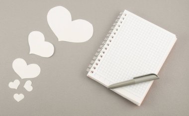 Gri arkaplanda beyaz kağıt kalpler