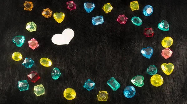 Siyah Kürk Arka Planında Beyaz Kağıt Kalpli Renkli Plastik Mücevherler — Stok fotoğraf