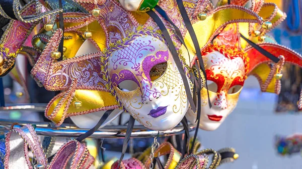 Escaparates con hermosas máscaras venecianas con plumaje para carnaval, diferentes productos, ropa, bufandas. Compras — Foto de Stock