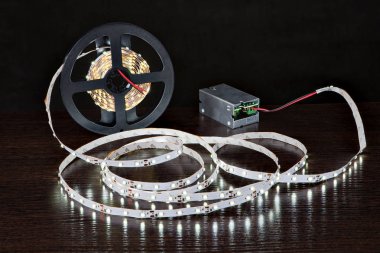 Bobin, güç kaynağı, siyah arka plan üzerine yakın üzerinde parlayan Led Strip ışık.