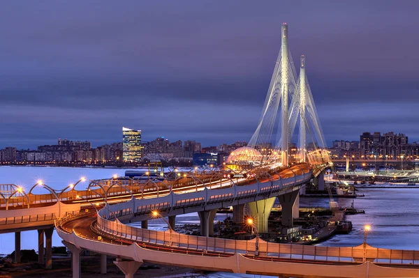 Noční pohled Petrovsky plavební Zavěšený most, St. Petersburg, Rusko. — Stock fotografie