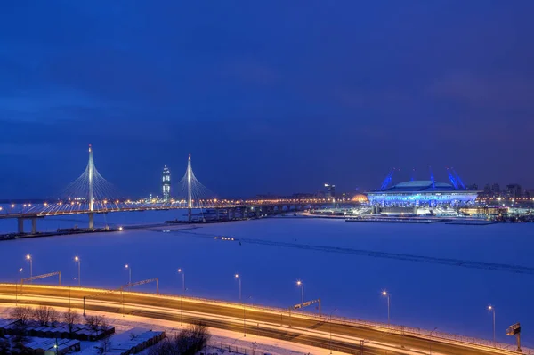 A háttérvilágítás éjszaka maradt-híd és a labdarúgó-stadion télen. — Stock Fotó