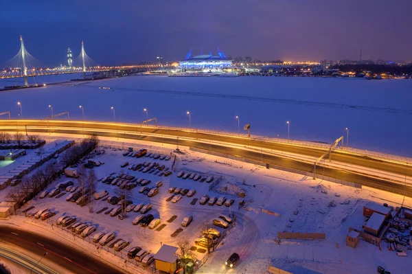 Téli város: éjszaka, ankerkötelekkel híd, a fagyasztott river labdarúgó-stadion — Stock Fotó