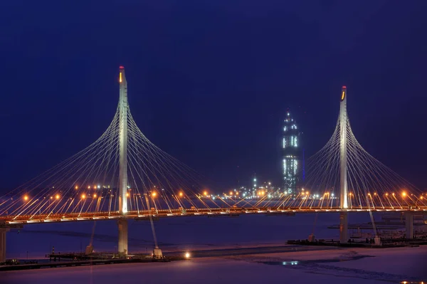 Stožáry a dráty zavěšeným mostem v noci osvětlení. — Stock fotografie
