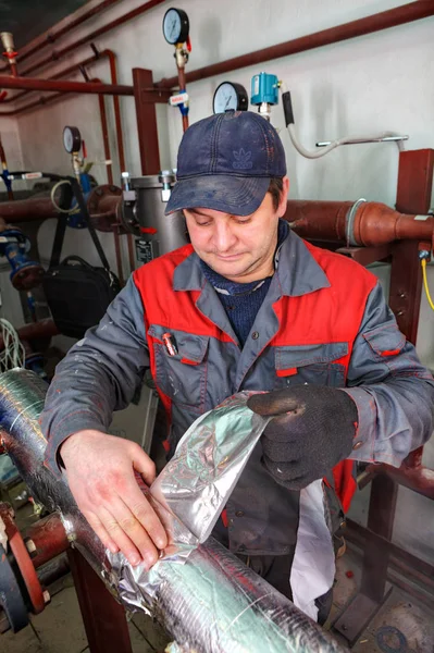 Ingeniero de fontanería reparador que trabaja en la sala de calderas, aísla la calefacción de tuberías . — Foto de Stock