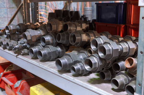 Threaded connectors for piping on a shelf in the storeroom.