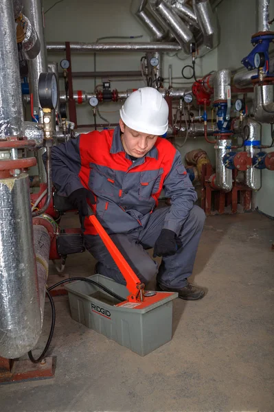 Encanadores de engenharia testando o sistema de aquecimento central usando bomba de teste de pressão . — Fotografia de Stock