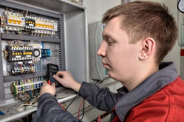 Electrician inspecting fuse box in industrial switchboard. — Stock Photo, Image